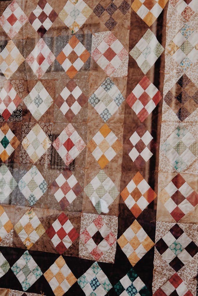 Close-up of a vibrant patchwork quilt showcasing colorful geometric diamond patterns.